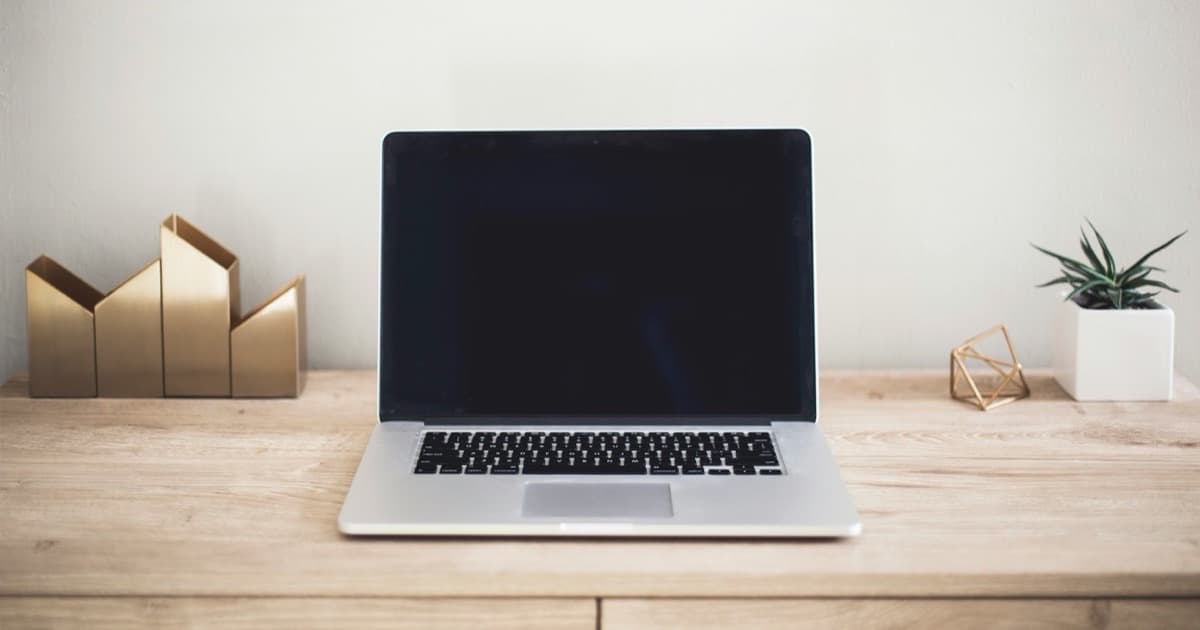 Laptop sobre un escritorio minimalista y ordenado, representando un agente de IA personal que trabaja por vos